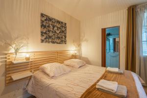 a bedroom with a large bed with two towels on it at Maison de vacances centre ville in La Tremblade