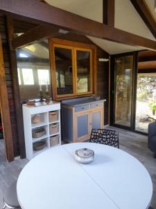 a kitchen with a white table and some windows at Chalet Dominique in Azzana