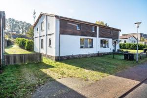 a small white and brown house in a yard at tierfreundliche Ferienwohnung in Adamshoffnung