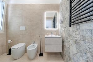 a bathroom with a toilet and a sink and a mirror at San Giorgio Rooms in Cavallino di Lecce +36 photos