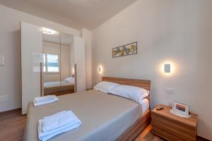 a bedroom with a large bed and a mirror at San Giorgio Rooms in Cavallino di Lecce