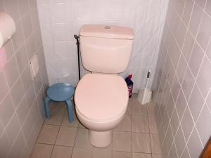 a white toilet in a bathroom with a blue stool at Le Paillassou in Blanzac