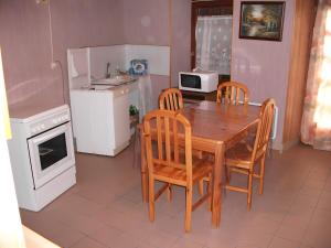 a kitchen with a wooden table and chairs and a microwave at Le Paillassou in Blanzac