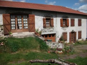 an old house with wooden windows and a yard at Le Paillassou in Blanzac