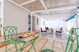 a living room with green chairs and a table at San Giorgio Rooms in Cavallino di Lecce