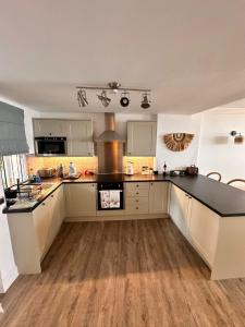 a kitchen with white cabinets and a black counter top at Parque Miraflores in Mijas