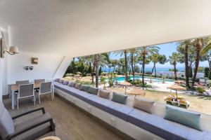 a room with a couch and a view of a pool at Parque Miraflores in Mijas