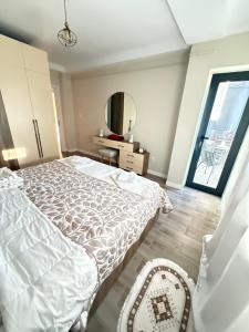 a bedroom with a white bed and a mirror at Panoramic View apartment Seraidi Annaba in Annaba