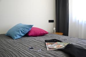 a bed with two pillows and a book on it at Ferienwohnung An Der Dorfkirche in Vipperow