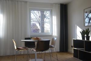 a dining room with a table and chairs and a window at Ferienwohnung An Der Dorfkirche in Vipperow