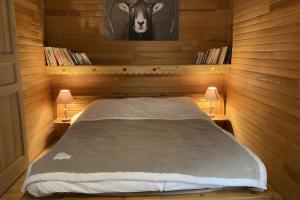 a bedroom with a bed with a cow picture on the wall at Chalet les Sonnailles in Mont-Dore