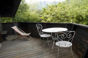 a patio with a table and chairs on a deck at Chalet les Sonnailles in Mont-Dore