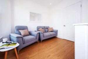 a living room with two blue chairs and a table at 21 Gyllyng Street in Falmouth