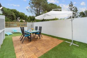 eine Terrasse mit Tisch und Sonnenschirm in der Unterkunft Ikigai in Buggerru