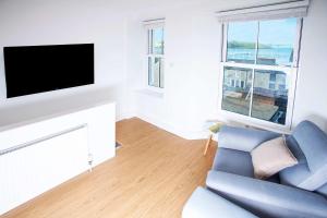 a living room with a blue couch and a flat screen tv at 21 Gyllyng Street in Falmouth