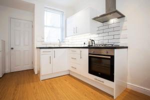 a kitchen with white cabinets and a stove top oven at 21 Gyllyng Street in Falmouth
