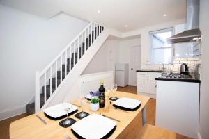 a kitchen with a table with wine glasses and a staircase at 21 Gyllyng Street in Falmouth +11 photos