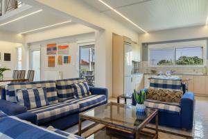 a living room with blue couches and a table at Artemida Beach House in Artemida