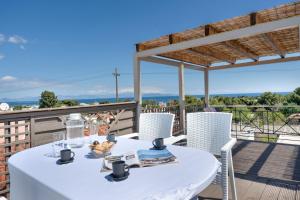 a white table and chairs on a balcony with a view at Artemida Beach House in Artemida