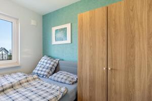 a bedroom with a bed and a wooden cabinet at Feel Free Apartment in Rheinböllen