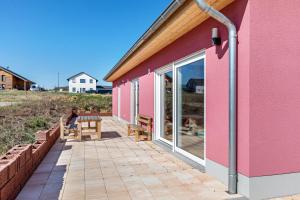 a pink house with a person sitting on a patio at Feel Free Apartment in Rheinböllen