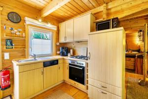 a kitchen with wooden cabinets and a stove top oven at Haus Miriam in Walchum