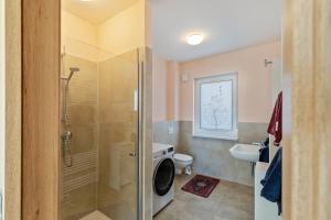 a bathroom with a shower and a washing machine at Feel Free Apartment in Rheinböllen +14 photos