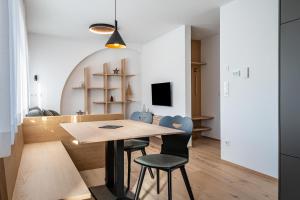a kitchen and dining room with a wooden table and chairs at Mountain Meadows Apt 1 in Valdaora