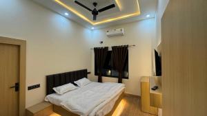 a bedroom with a bed with a ceiling fan at iv hotel Ajmer in Madār