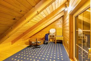 a attic room with a wooden ceiling and a chair at Haus Miriam in Walchum