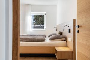 a bedroom with a bed and a window at Mountain Meadows Apt 1 in Valdaora