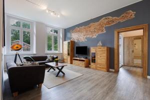 a living room with a couch and a tv at Reit- und Ferienhof Alte Dorfschule in Holstenniendorf