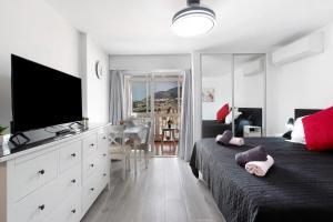 a bedroom with two beds and a flat screen tv at Apartamento Agata 2024 in Benalmádena