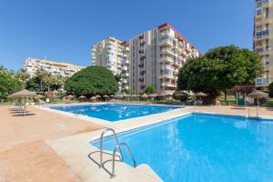 a swimming pool in front of some apartment buildings at Apartamento Agata 2024 in Benalmádena