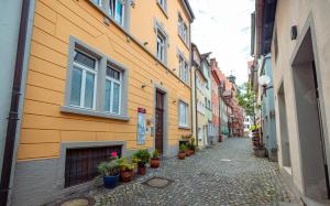 an alley with potted plants on the side of a building at Alte Konditorei in Lindau