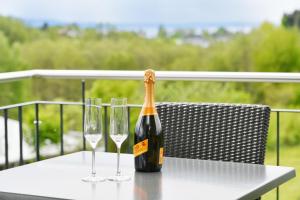 a bottle of champagne and two wine glasses on a table at Dinkelbach Feriendomicil 2 C in Lindau-Bodolz +22 photos