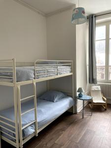 a bedroom with two bunk beds and a table at Villa Isabelle in Allevard