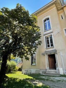 a house with a tree in front of it at Villa Isabelle in Allevard