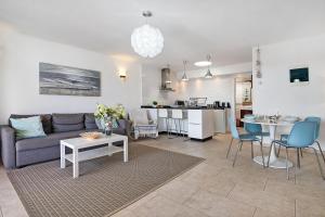 a living room and kitchen with a couch and a table at Puerto Chico T in Playa Blanca