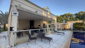 a house with a balcony with chairs and a swimming pool at Flat 707 Moderno e Espaçoso, próximo ao Praia Clube in Uberlândia