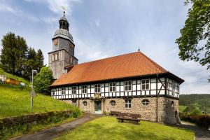 an old building with a clock tower on a hill at Ferienhaus Bergmann mit Sauna in Wildemann