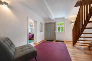 a living room with a couch and a stair case at Ferienhaus Bergmann mit Sauna in Wildemann