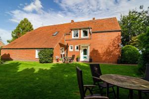 a house with a table and chairs in the yard at Ferienwohnung Didi in Detern