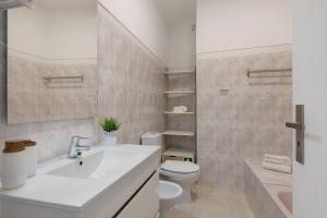 a bathroom with a white sink and a toilet at Refúgio Estrela do Mar in Quarteira +15 photos