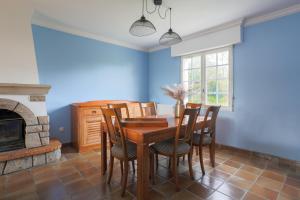 a dining room with blue walls and a table and chairs at Les Camelias in Locquirec +19 photos