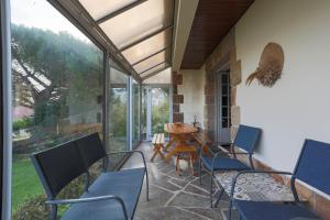a patio with blue chairs and a table and a tableearcher at Les Camelias in Locquirec