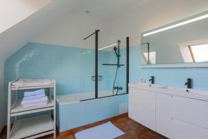 a blue bathroom with a shower and a sink at Les Camelias in Locquirec