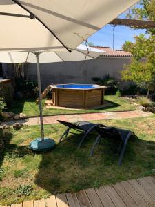 an umbrella and a picnic table and a pool at l'atelier by Emma in Bommes