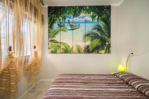 a bedroom with a bed with a painting on the wall at Appartamento Croce del Sud 8 in Bibione