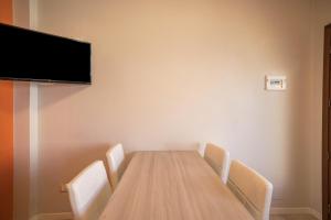 a conference room with a table with chairs and a flat screen tv at Appartamento Croce del Sud 8 in Bibione